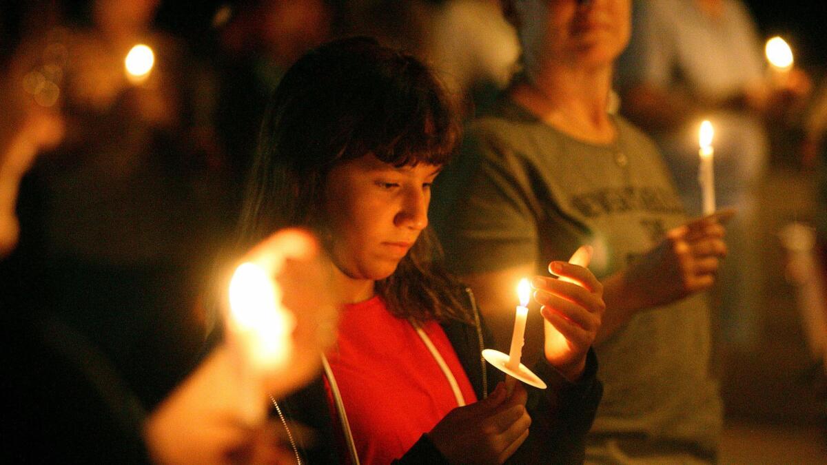 Valen Aznavourian, 12, of Glendale, watches the flame of her candle at a candlelight vigil in front of the church at the Lights for Liberty event at the La Cañada Congregational Church on Friday.