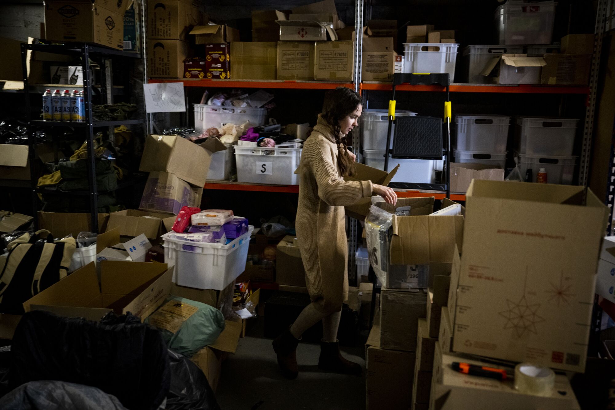 A woman concentrates on a task in the middle of a warehouse 