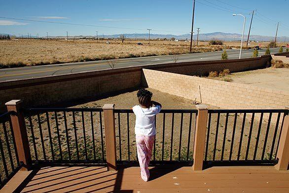 Trinity Essence Lee, 4, looks out over her family's dried out backyard, which they cannot water or landscape because of water shortages in Lancaster's Westview Estates.