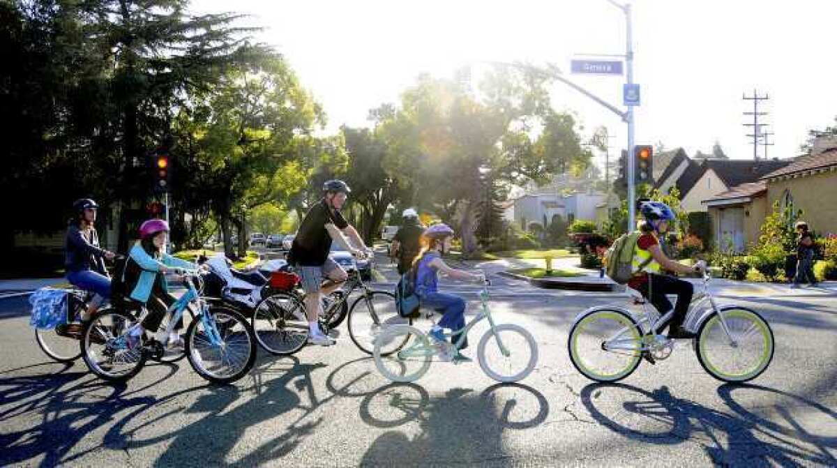 A group of R.D. White Elementary School students cross Glenoaks Boulevard on Geneva Sreet in Glendale on Wednesday for the first National Bike to School Day. 30 students, it was estimated, rode their bikes to school, several for the first time.