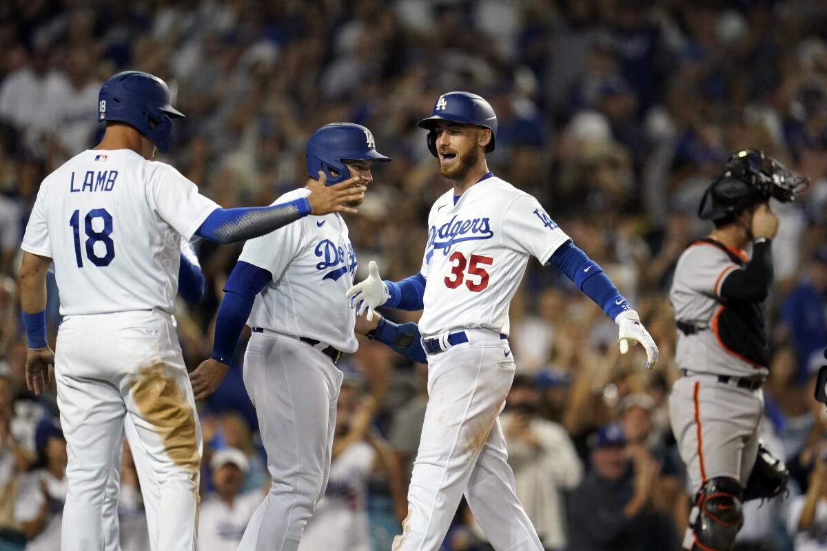 Cody Bellinger, right, celebrates with Max Muncy, center and Jake Lamb after hitting an eighth-inning grand slam.