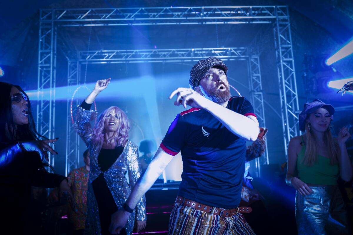 A man and woman dance in a nightclub in a scene from "Ted Lasso."