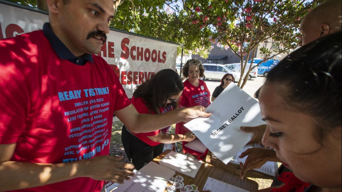 Thomas Starr King Middle School teacher Joel Laguna hands out ballots to LAUSD colleagues to vote on whether they will allow their union's leadership to call a strike in Los Angeles, Calif. on Aug. 23.