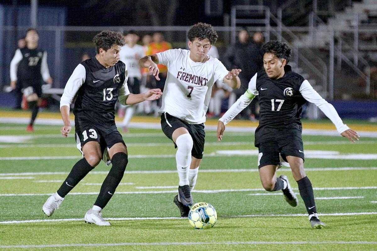 Fremont striker Franklin Orellena dribbles between Luis Viera and Edgar Auscencio, of Marquez