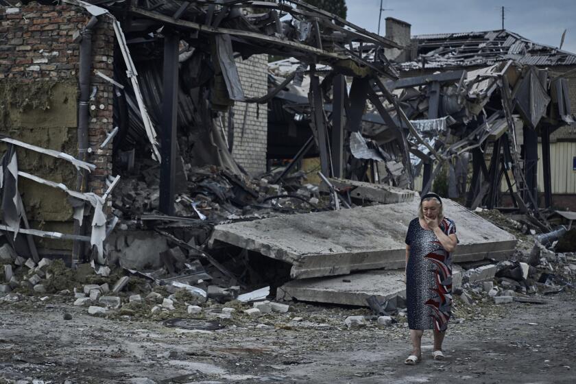 A woman reacts at the scene of a building damaged after recent Russian missile strikes in Pokrovsk, Donetsk region, Ukraine, , Wednesday, Aug. 9, 2023. (AP Photo/Libkos)