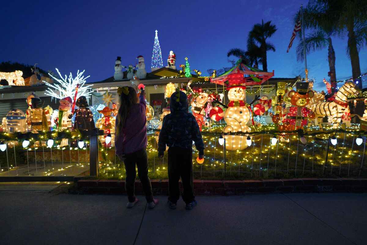 Troy Guzman, 3, and Zaya Guzman, 4, look at Christmas lights at 1639 Knob Hill Road in San Marcos 
