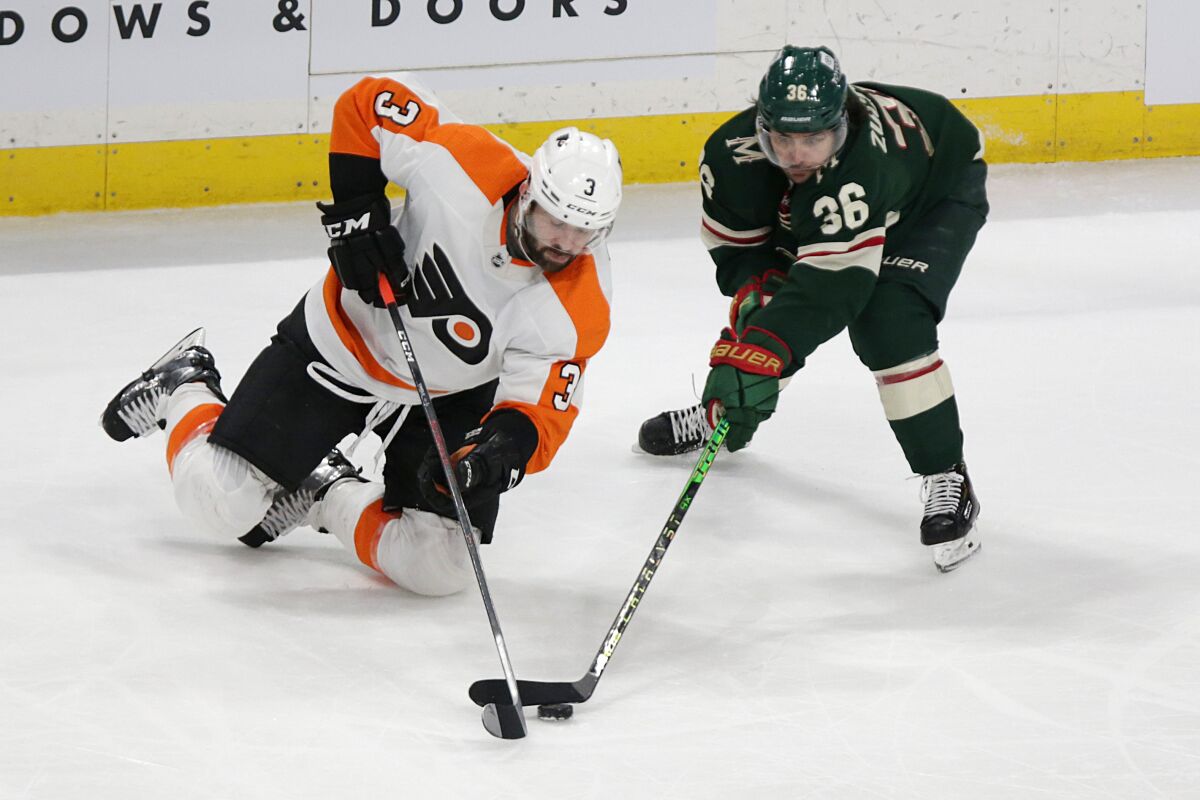 Philadelphia Flyers defenseman Keith Yandle (3) and Minnesota Wild right wing Mats Zuccarello (36) battle for the puck in the third period of an NHL hockey game Tuesday, March 29, 2022, in St. Paul, Minn. (AP Photo/Andy Clayton-King)