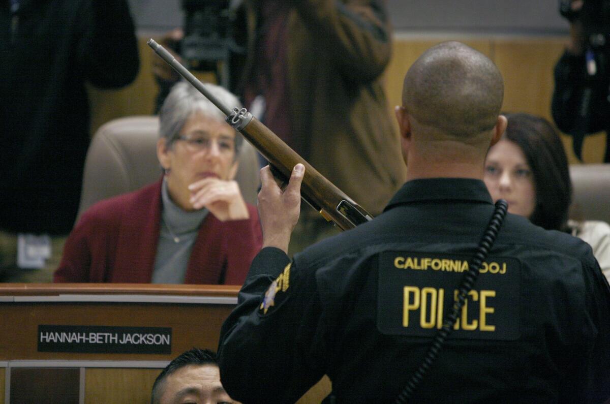 State Sen. Hannah-Beth Jackson (D-Santa Barbara) looks at a sem-automatic rifle during a joint legislative informational hearing on gun control at the Capitol on Jan. 29, 2013.