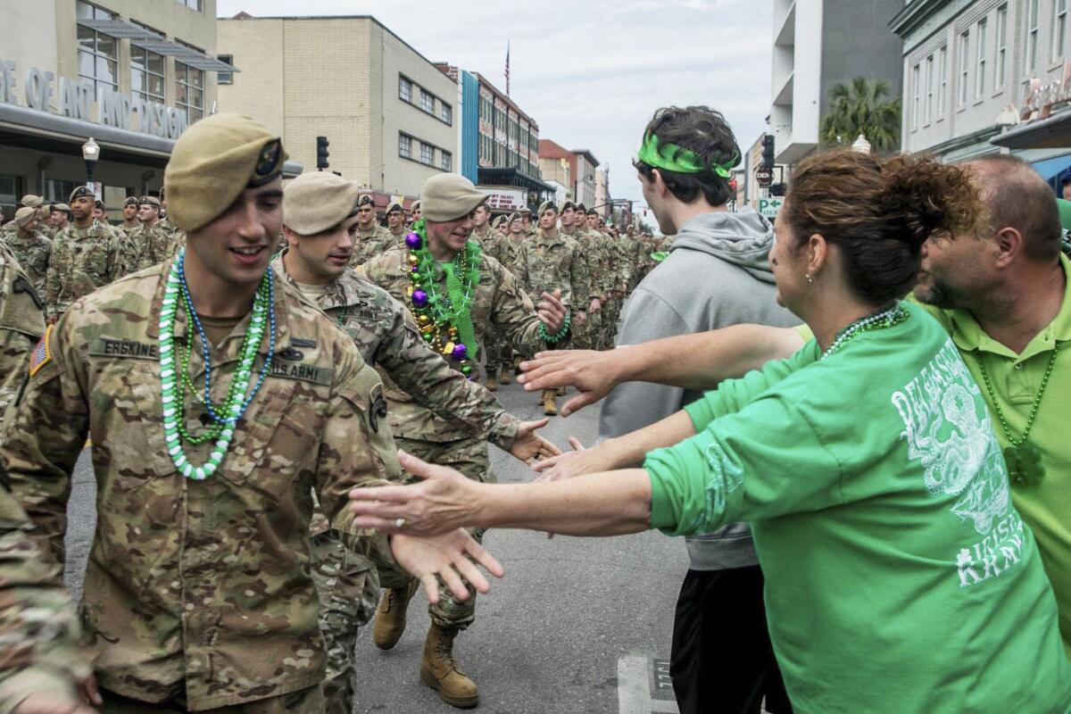 Revelers greet troops in a St. Patrick's Day parade