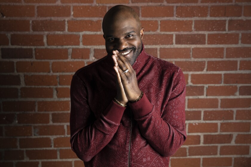 Actor Carl Clemons-Hopkins puts their hands together.