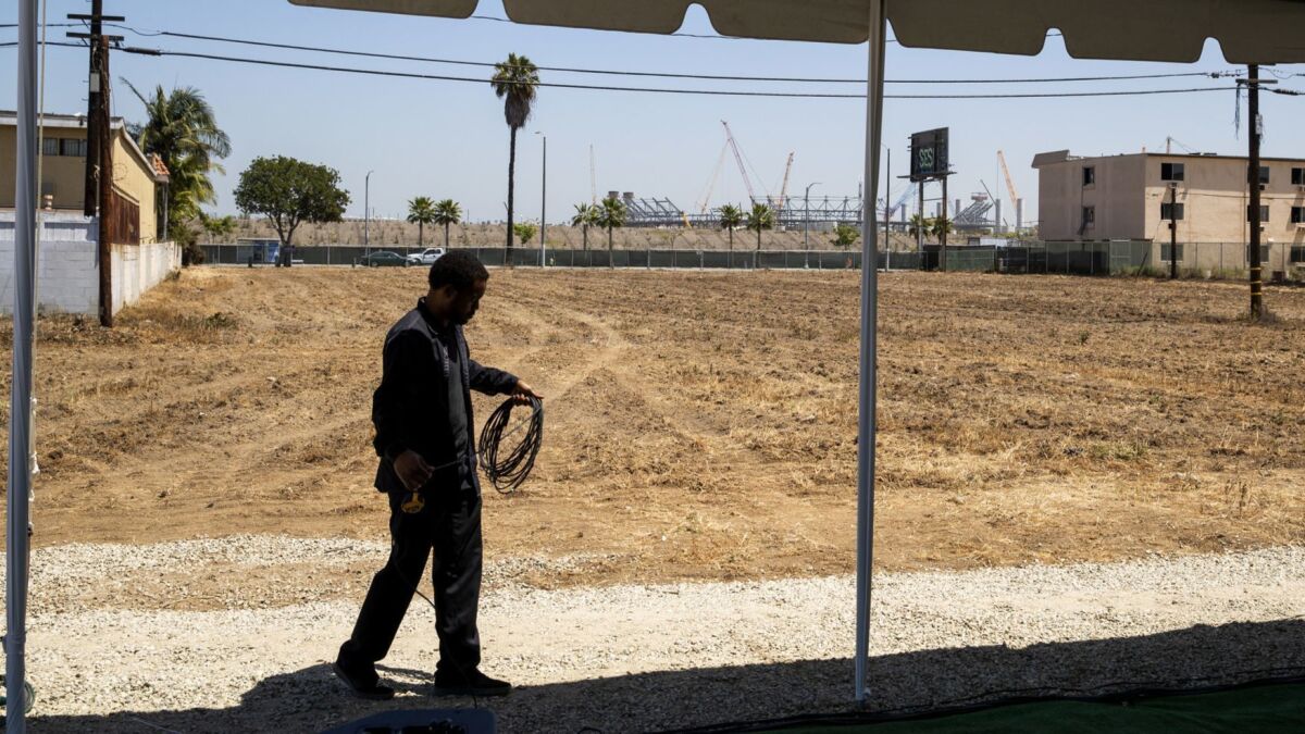 A view of the parcel of land for the proposed Clippers arena project in Inglewood, not far from the new NFL stadium construction (background).
