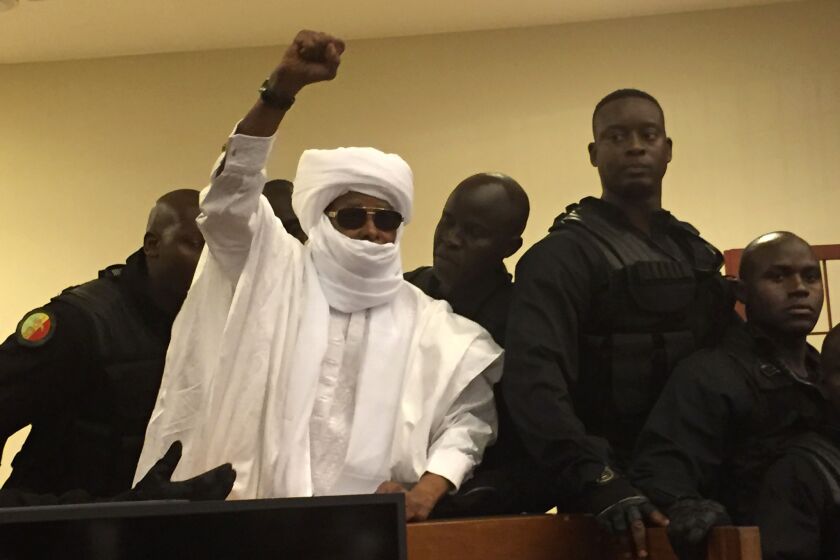 Chad's former dictator Hissene Habre raises his hand during court proceedings in Dakar, Senegal, on Monday.