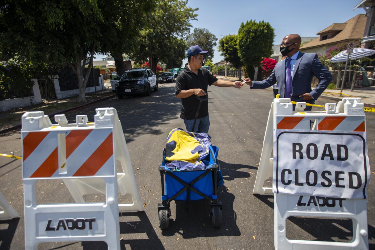 Mario Delgado, left, brings milk and food home for his family in a wagon on East 27th Street in Los Angeles.