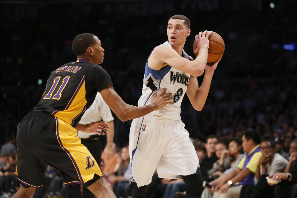 Timberwolves guard Zach LaVine looks to pass as Lakers forward Wesley Johnson defends.