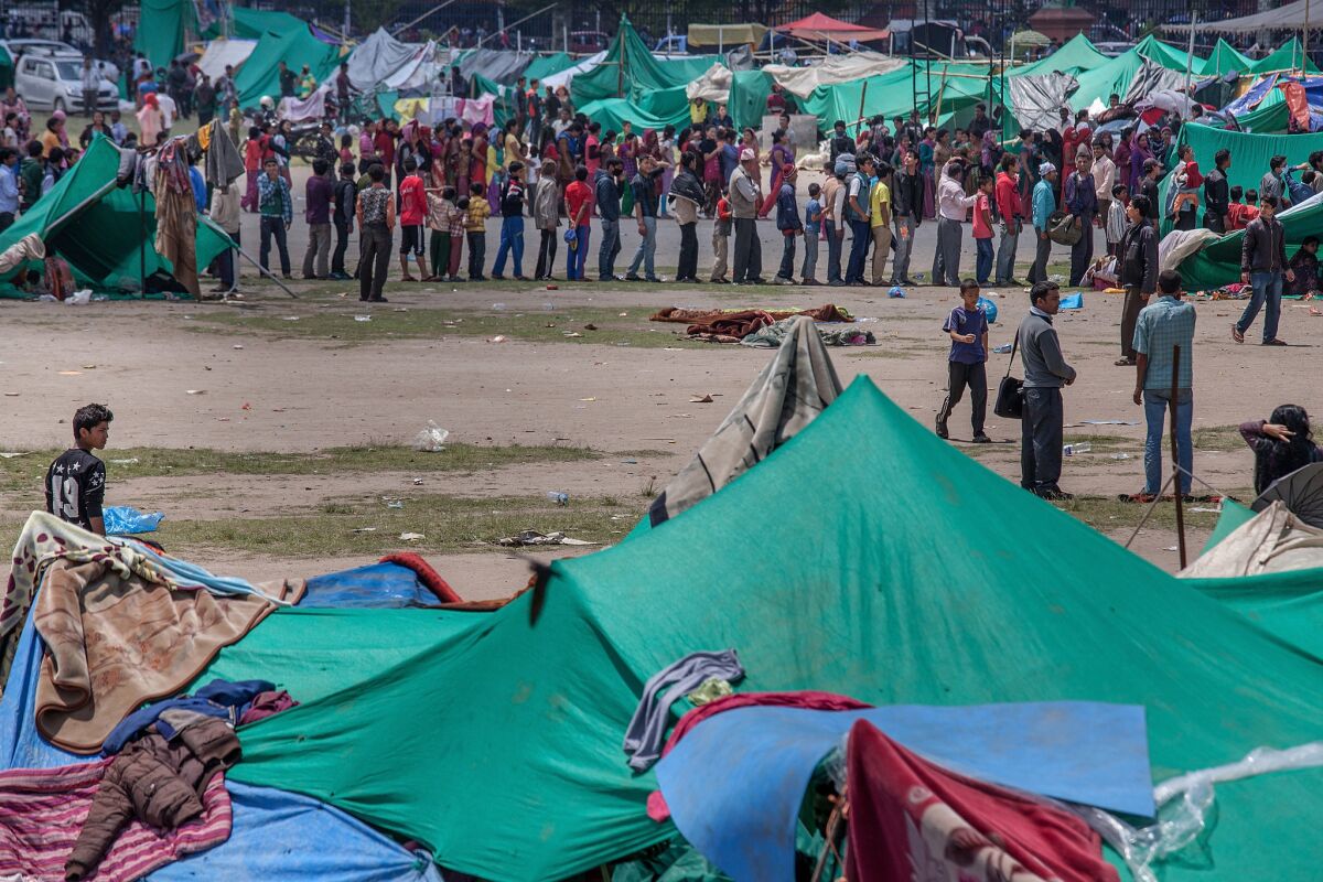 Residents line up for food in an evacuation area set up by the authorities in Tundhikel park in Katmandu, Nepal, on Monday.