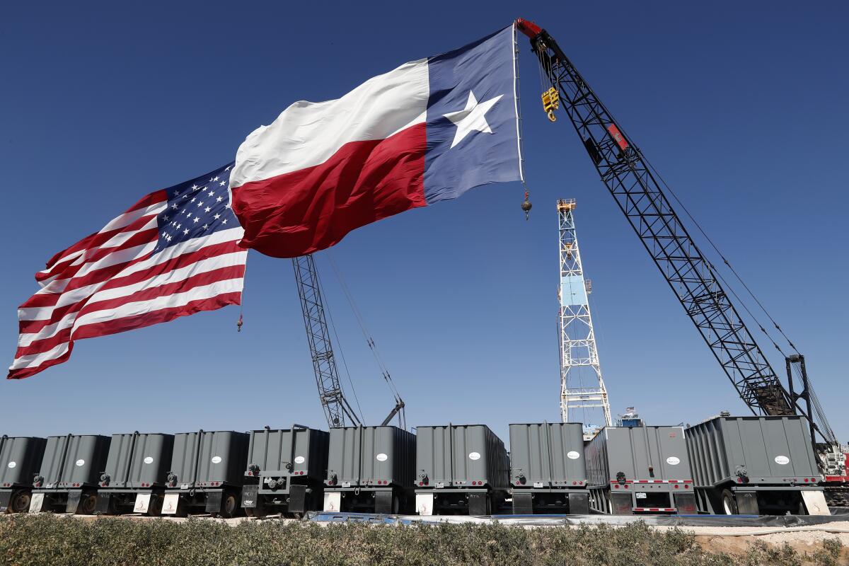 The American and Texas flags near an oil rig