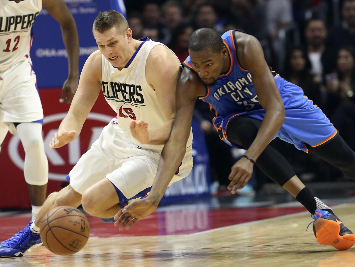 Clippers center Cole Aldrich and Thunder forward Kevin Durant go after a loose ball during the first quarter on Dec. 21.