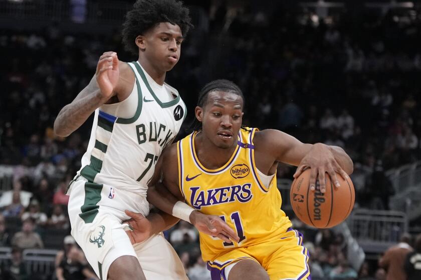 The Lakers' Quincy Olivari tries to get past the Bucks' AJ Johnson during a preseason game Thursday in Milwaukee. 