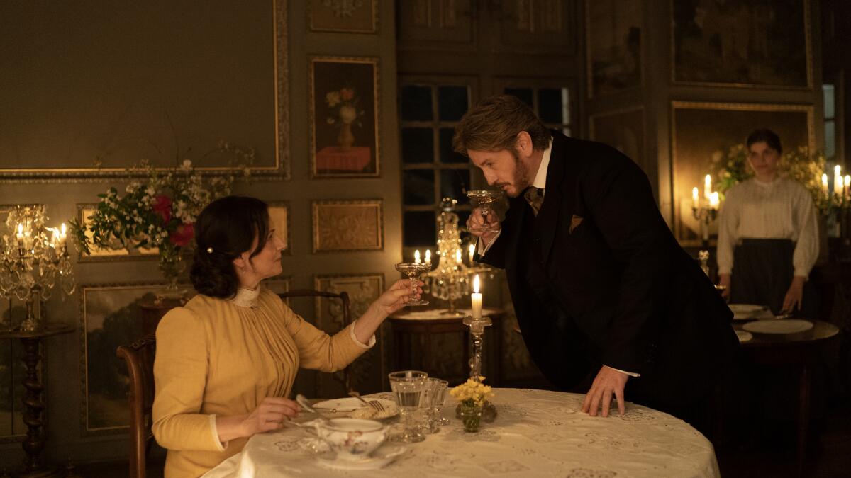 A woman and a man raise glasses over a fine meal.