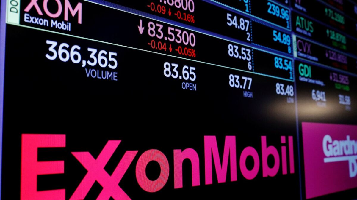 A logo of Exxon Mobil is displayed on a monitor above the floor of the New York Stock Exchange shortly after the opening bell on December 2017.