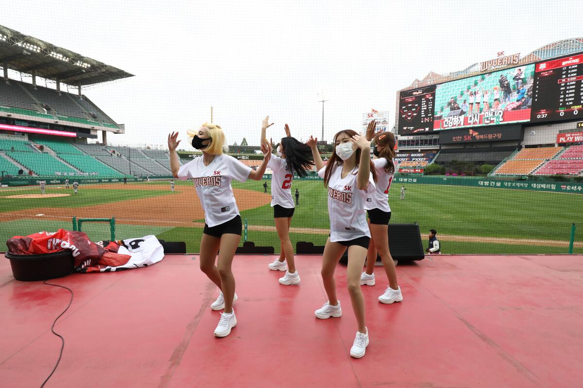 Cheerleaders dance on top of a dugout at Happy Dream Ballpark during a spectator-free KBO game between SK Wyverns and Hanwha Eagles on May 5 in Incheon, South Korea.