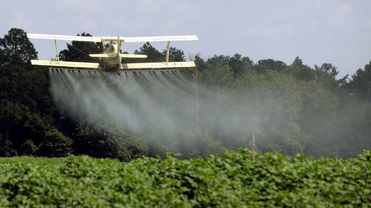 A crop duster sprays a field just outside Headland, Ala., in 2009.