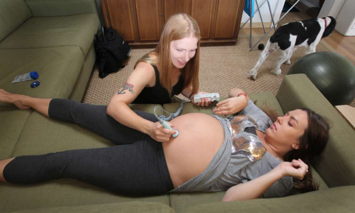Rebecca Prediletto, a licensed midwife, conducts a prenatal exam on Amy Terranova, who opted to deliver her baby at her Silverlake home.