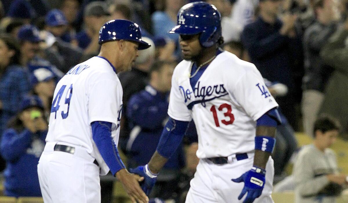 Dodgers shortstop Hanley Ramirez gets a low-five from third base coach Lorenzo Bundy after hitting a solo home run in the eighth inning against the Phillies on Wednesday night at Dodger Stadium.