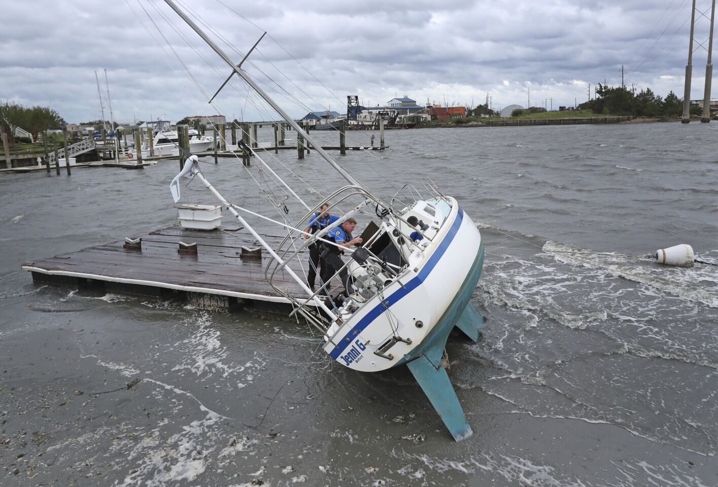 Beaufort Police Officer Curtis Resor, left, and Sgt. Micheal Stepehens check a sailboat for occupants in Beaufort, N.C. after Hurricane Dorian passed the North Carolina coast.