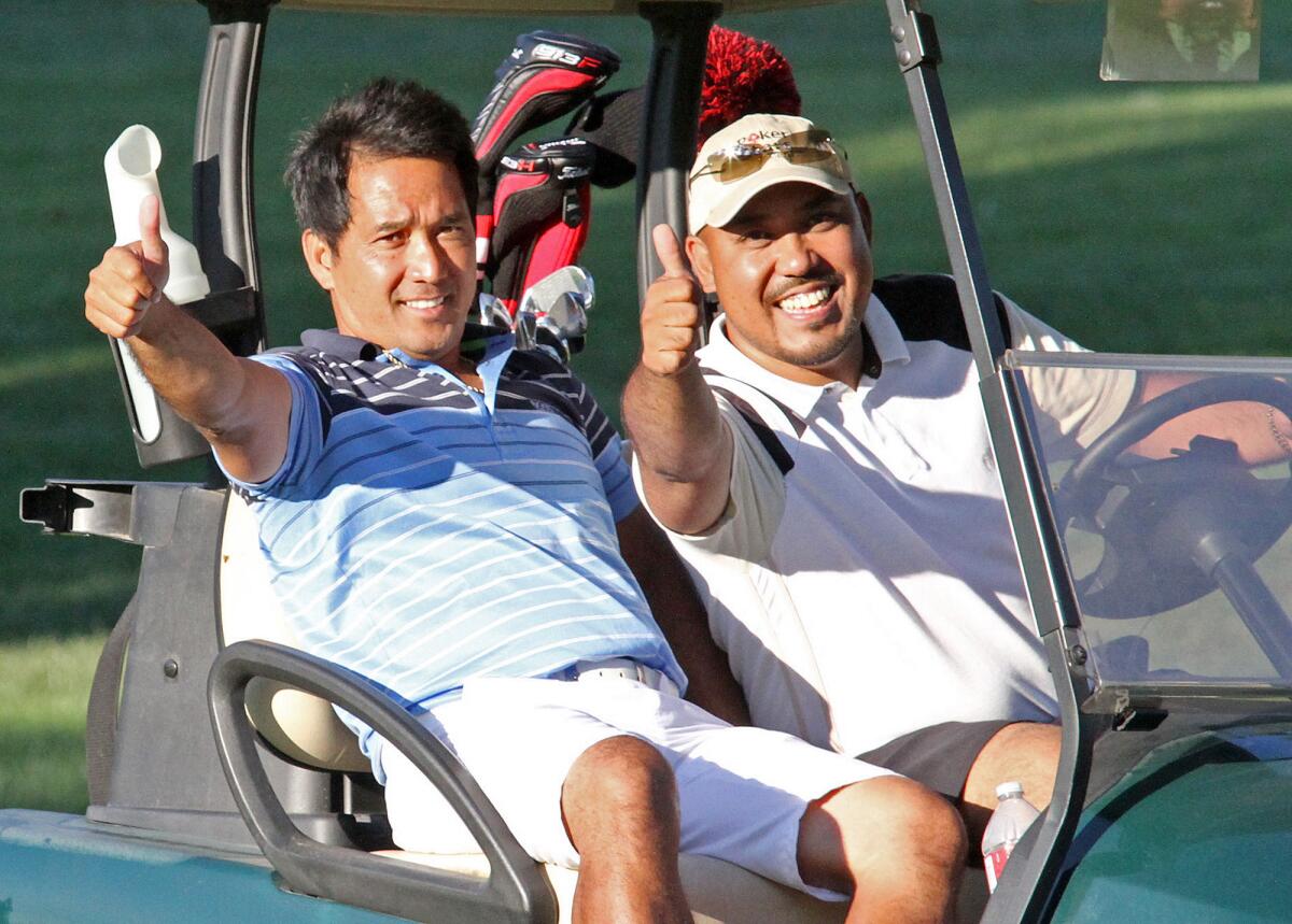 Ferdie Barbosa and his caddy Reggie Casasola are thumbs up after a well-played drive from a long distance on the 18th fairway to land on the green at Oakmont County Club in Glendale for the second annual Glendale Golf Championship presented by the Glendale Parks & Open Space Foundation on Monday, July 29, 2013.