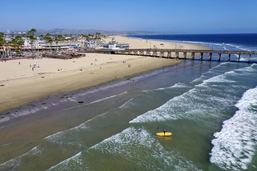 NEWPORT BEACH, CA -- MONDAY, MAY 4, 2020: An aerial view of a few surfers and beach-goers enjoying a nice day at the beach despite Gov. Gavin Newsom's hard closure, which is still in place in Newport Beach, CA, on May 4, 2020. (Allen J. Schaben / Los Angeles Times)