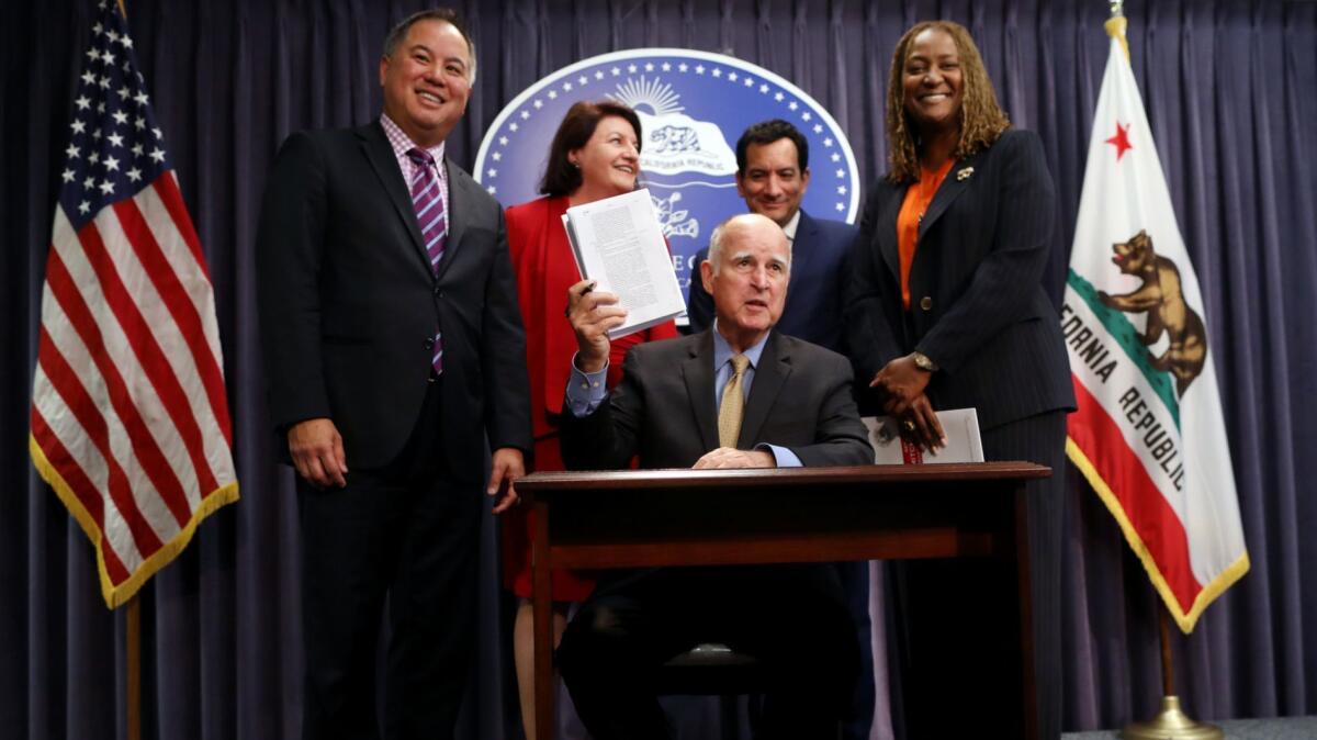 Gov. Jerry Brown with, from left, Assemblyman Phil Ting, Senate President Pro Tem Toni Atkins, Assembly Speaker Anthony Rendon and Sen. Holly Mitchell as he signs the California budget Wednesday.