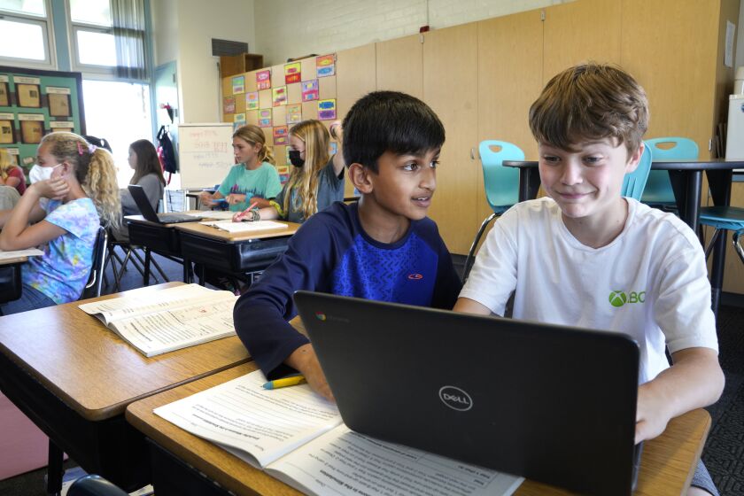 Redondo Beach, California-Devak Mistry, age 10, left, and Cash Minzlaff, age 11, right, do their assignment in their 5th grade class at Tulita Elementary School. At Tulita Elementary School in Redondo Beach, California students were given the option to attend with or without wearing a masks on March 14, 2022, the first day that that students across Los Angeles County have the option to remove their masks in class. L.A. Unified School District is an exception and students are still required to wear masks. (Carolyn Cole / Los Angeles Times)