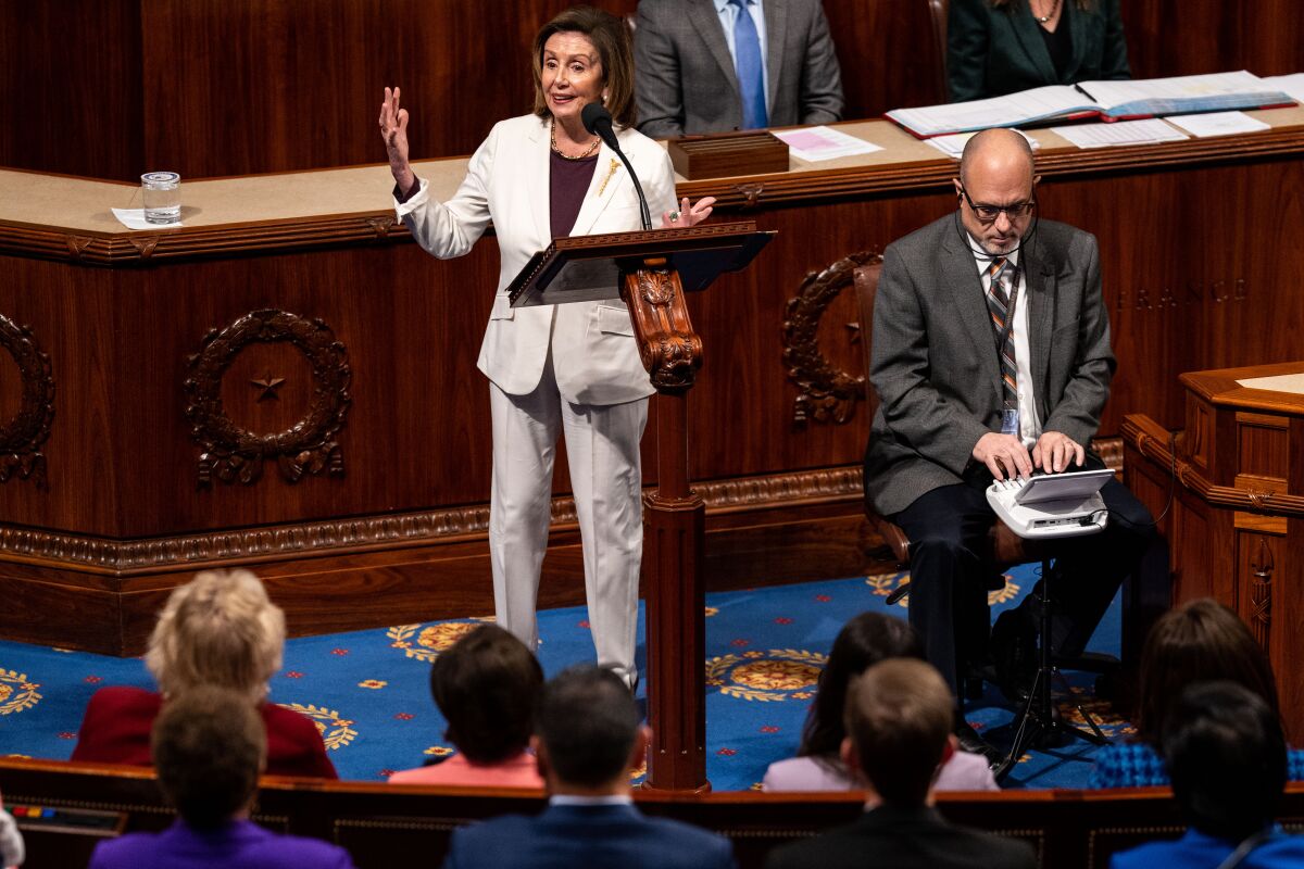 Nancy Pelosi speaks at a lectern on the House floor