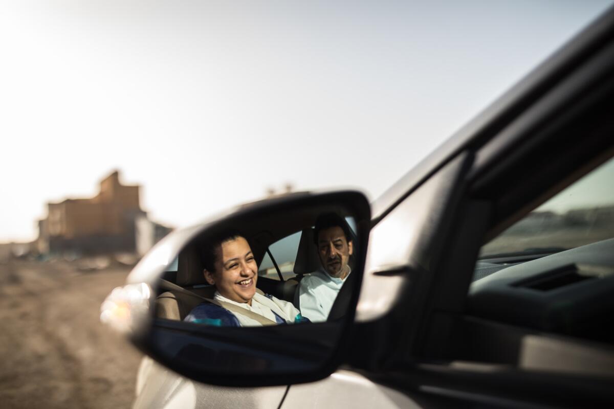 Tala Murad receives a driving lesson from her father, Midhat.