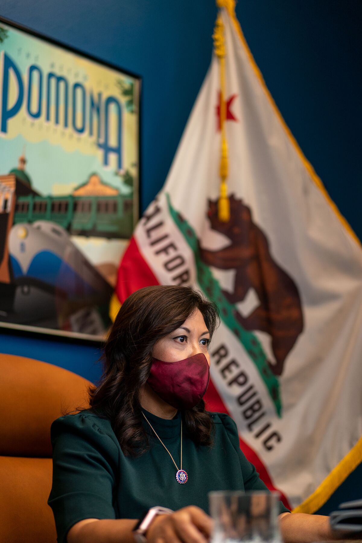 U.S. Rep. Norma Torres sits in front of a California flag and a framed Pomona poster.