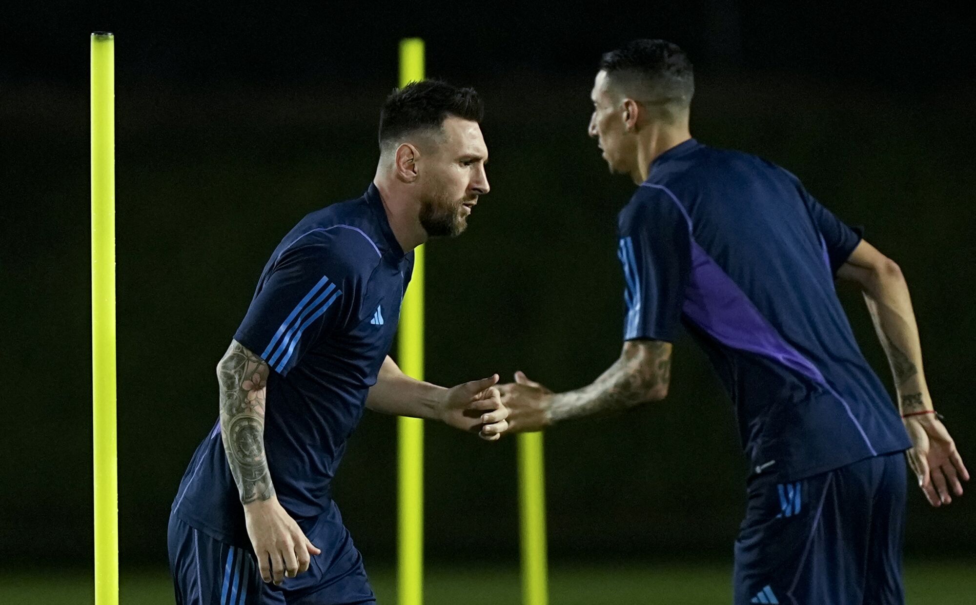 Argentina's Lionel Messi (left) and Angel Di Maria warm up during a training session in Doha, Qatar on Thursday.