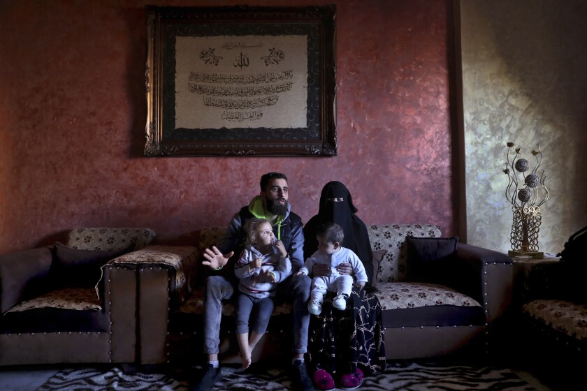 Ziad Khaled Hilweh, 23, who tried to migrate to Europe with his family, speaks during an interview as he sits with his wife Alaa Khodr, 22, his daughter Jana 2 year-old and his son Karim 3 months, at his parents house in the northern city of Tripoli, Lebanon, Monday, Dec. 6, 2021. Lebanese are setting off from the port city of Tripoli to attempt the perilous journey by boat to Cyprus and beyond in the hopes of reaching Europe. They are joining Iraqis, Afghans and Sudanese in leaving their homeland after Lebanon's economic collapse has thrown two-thirds of the population into poverty in just over a year. (AP Photo/Bilal Hussein)