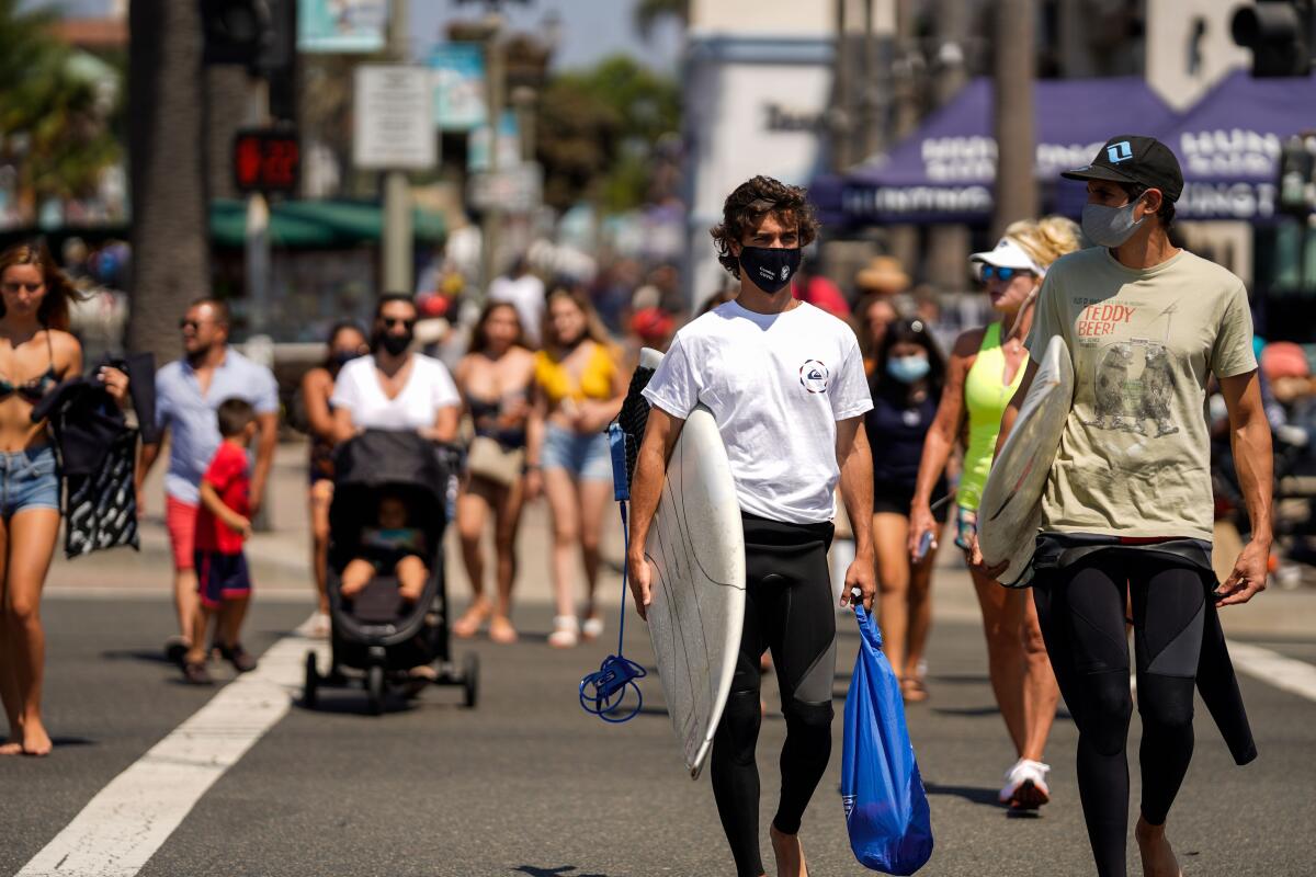 Surfers wearing face coverings in Huntington Beach