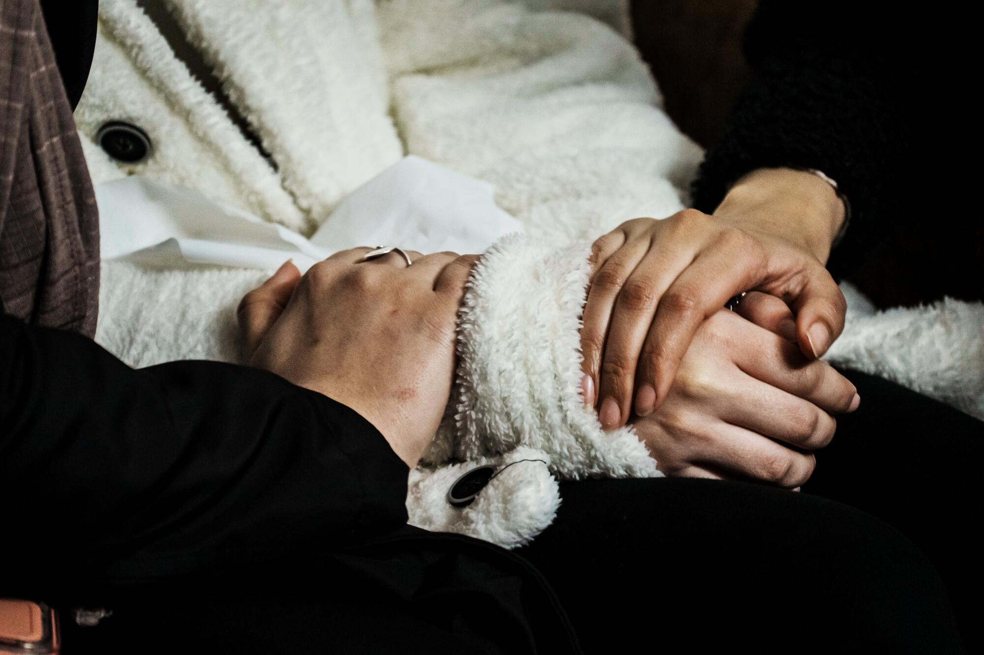 Al-Ghazzawi members are comforted by community members as they mourn the death of their two children.