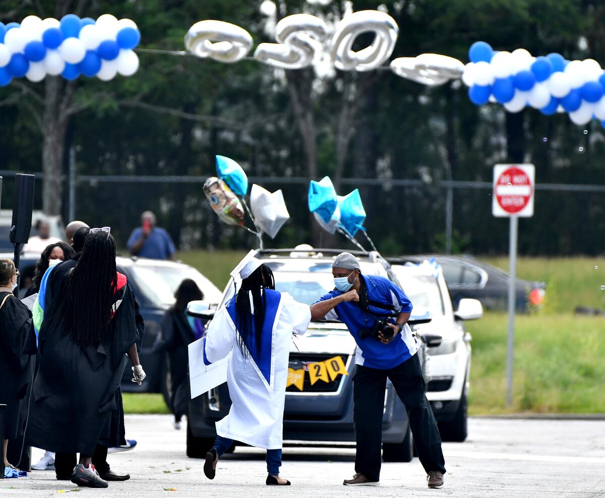 A drive-through high school graduation in College Park, Ga. Schools are wrestling with how to approach the new school year.