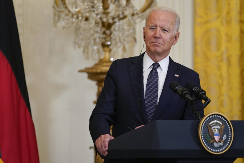 President Biden stands at a White House podium.