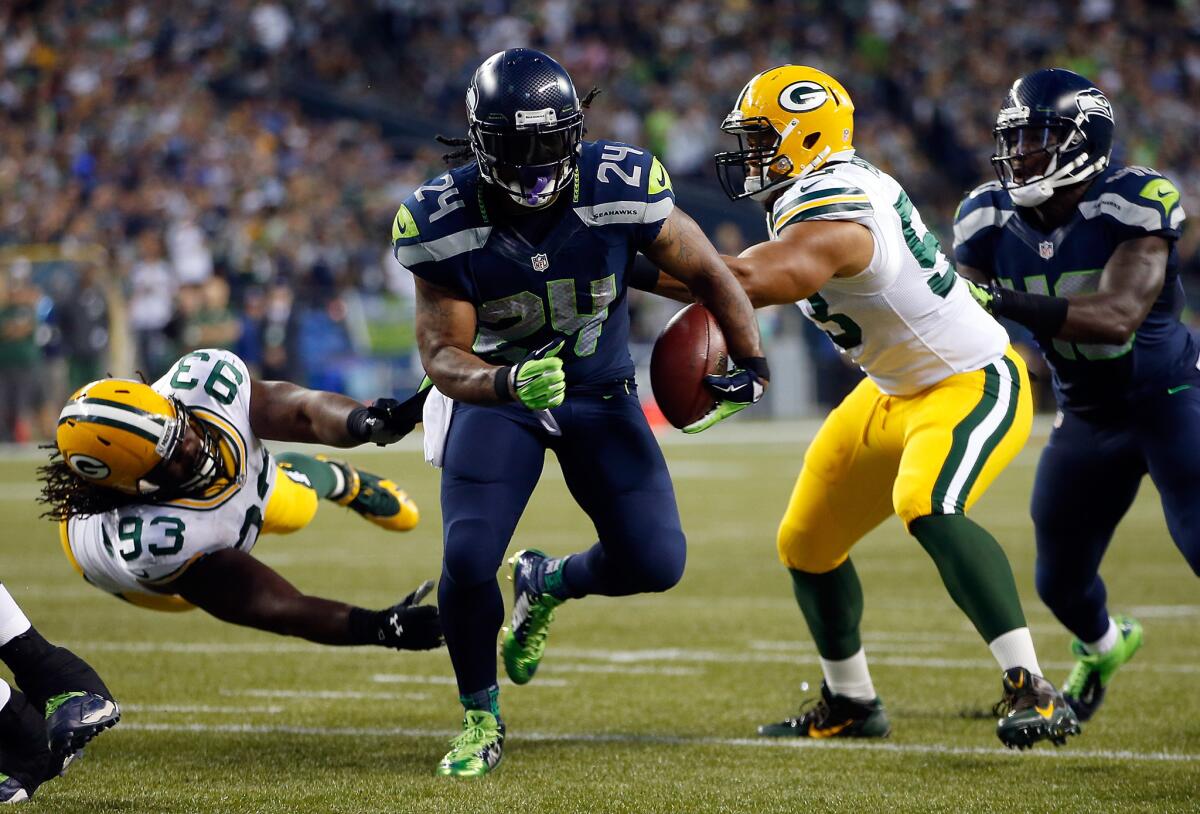 Seattle's Marshawn Lynch avoids Green Bay's Josh Boyd, left, and Nick Perry on his way to the end zone Sept. 4.