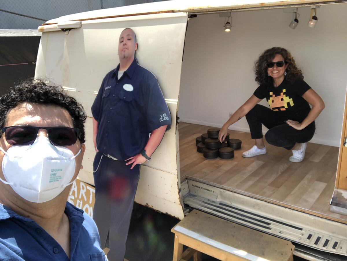 Artist Ruben Ochoa in a mask with a van in the background, where Carolina sits near a mound of bronze tortillas