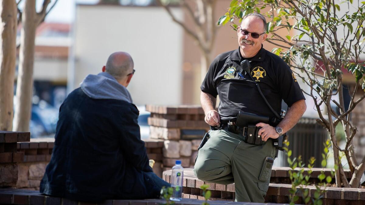 Deputy Chet Parker, Lake Forest’s homeless liaison officer, talks with a man on Feb. 21.