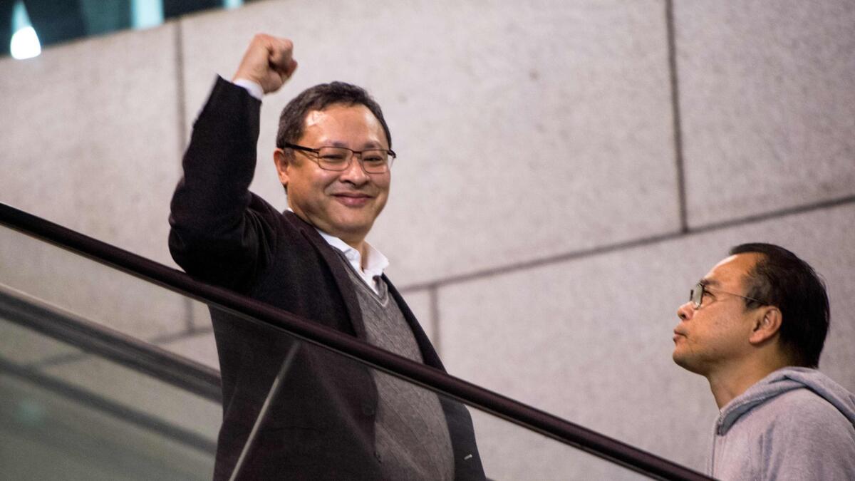 Activist Benny Tai gestures to supporters as he enters a police station before his arrest in Hong Kong on March 27, 2017.