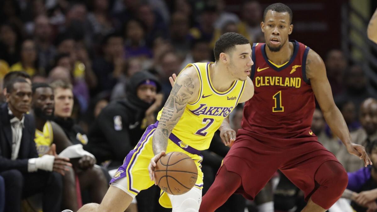 Lakers' Lonzo Ball (2) drives past Cleveland Cavaliers' Rodney Hood (1) in the first half of a game Wednesday in Cleveland.