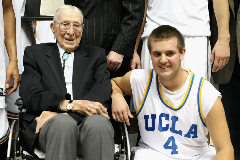 Legendary UCLA coach John Wooden poses with great-grandson Tyler Trapani following a game in 2008.