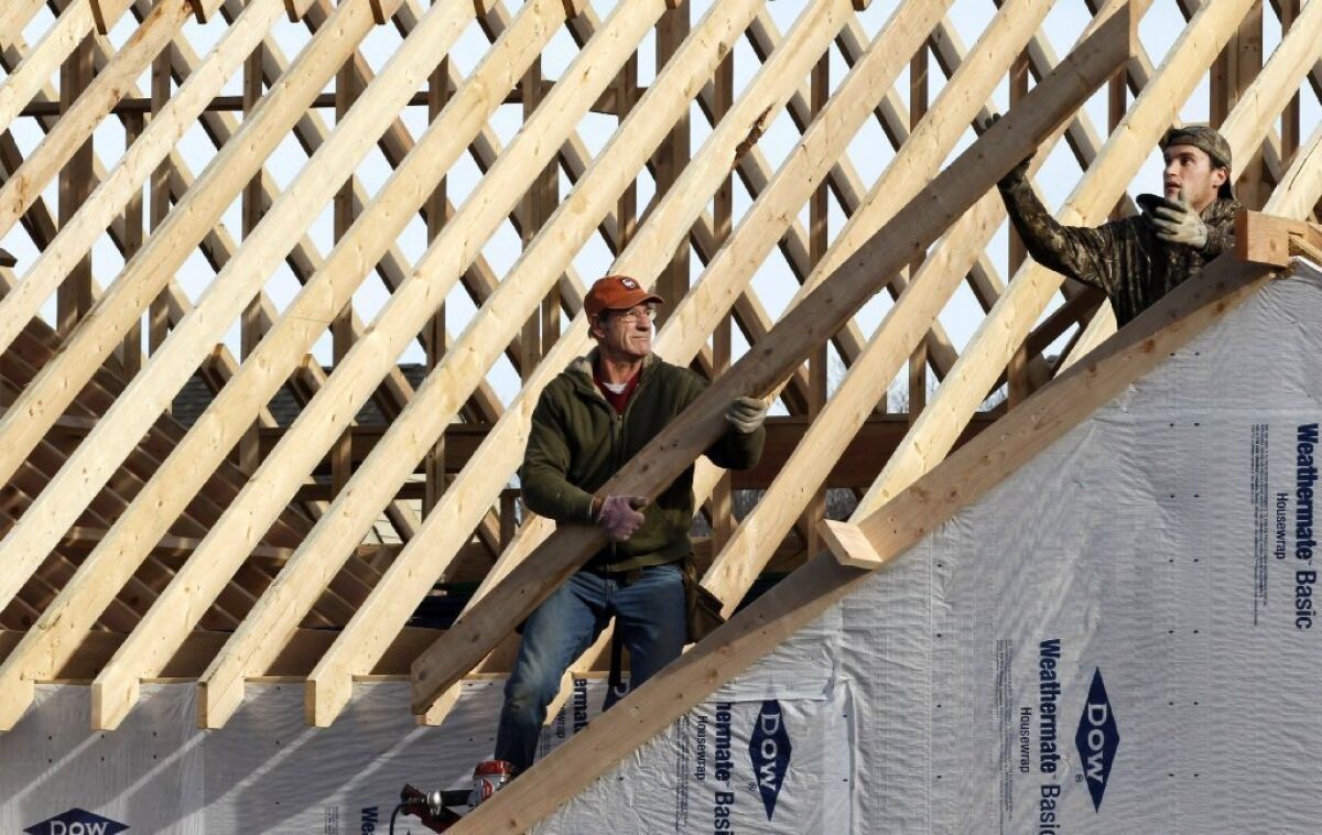 Construction workers build a home in Pepper Pike, Ohio, in December. The Commerce Department said Friday that construction spending increased 0.9% in December from the previous month.