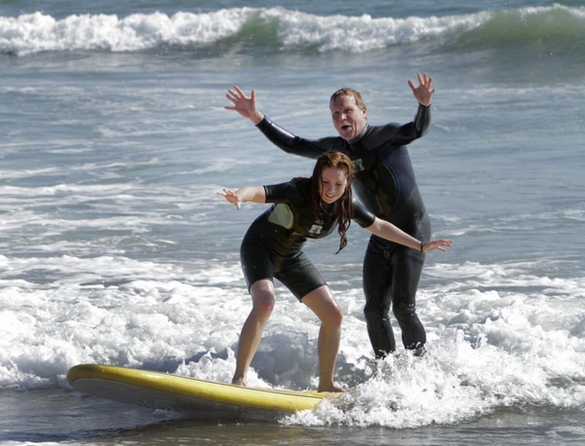 A tandem ride is a blast for Chris Erskine and his younger daughter at surfing school in Santa Monica.